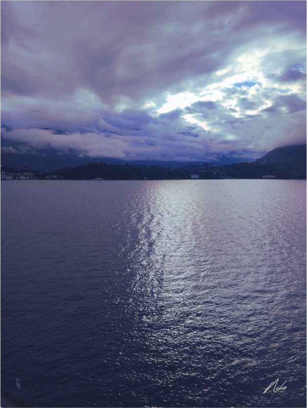 Photographie d'art verticale de lac : lumière descendant du ciel et se prolongeant sur l'eau