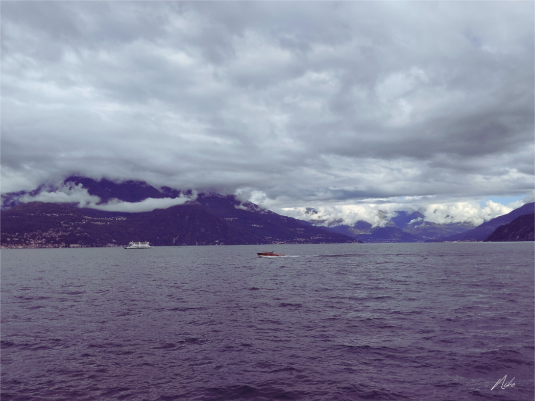 Photographie d'art de lac et de montagnes : présence minuscule traversant un paysage immense