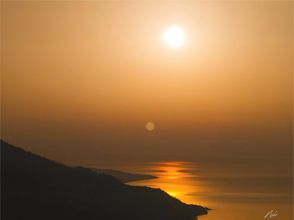 Photographie d'art marine : soleil couchant sur l'horizon, reflet traversant la mer